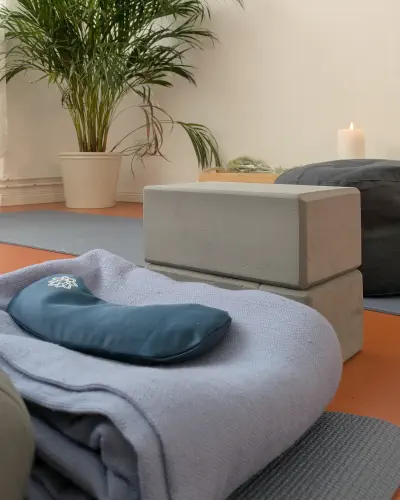 Yin-Yoga-Props im Studio: Decke, Augenkissen und Blöcke auf der Matte