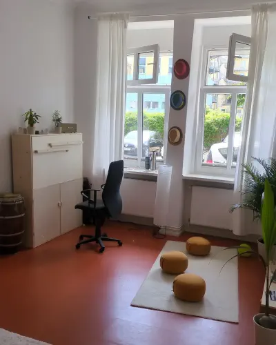 Das Studio mit großen Fenstern, Sitzkissen und Arbeitsplatz